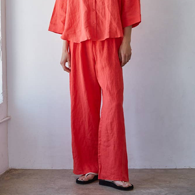 Person wearing a bright red outfit against a plain background