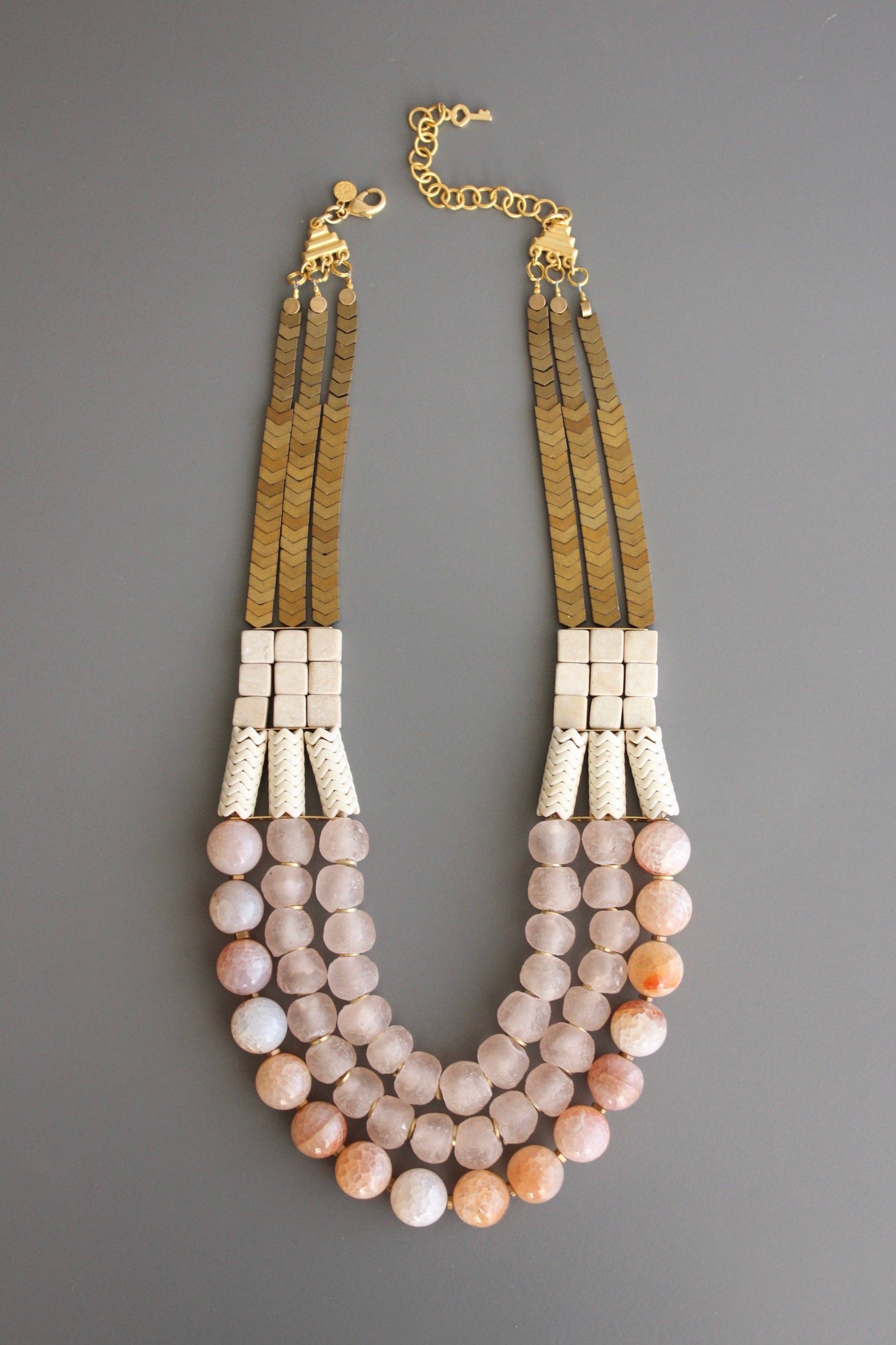 Triple strand necklace with hematite, magnesite, fire agate, glass, and brass