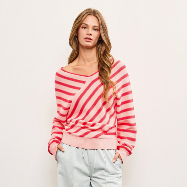 Front view of a pink and red Cross Stripe V Neck Sweater Top, featuring diagonal stripes, a relaxed fit, and lightweight 100% cotton fabric.