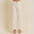 Front view of white high-rise wide-leg cotton twill pants with double-button waist and full-length hem, styled with heeled sandals.

