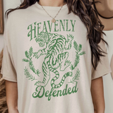 Close-up of a woman wearing the "Heavenly Defended" oversized graphic tee featuring a green tiger and laurel design.