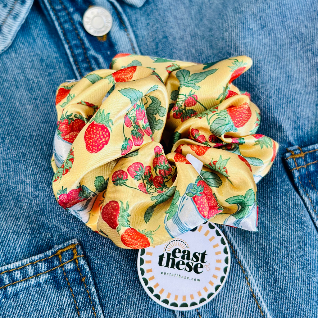 Yellow scrunchie with strawberry pattern on a denim background